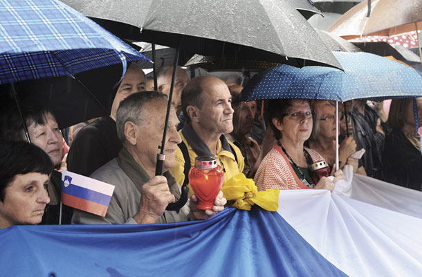 Foto tedna: Dežniki, sveče, zastava pred ljubljanskim sodiščem v čast zaprtega Janeza Janše