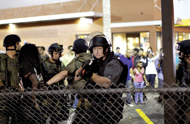 Preplašeni policist z nabito puško med protesti v Fergusonu