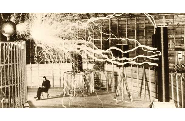 Nikola Tesla in njegov oddajnik za prenos električne energije v laboratoriju v Colorado Springsu. Fotografijo, ki je nastala s tehniko večkratne osvetlitve (multiple exposure), je posnel fotograf Dickenson Alley za Teslin članek z naslovom Problem povečevanja človeške energije, ki ga je junija 1900 objavila ameriška revija The Century Magazine.  