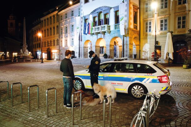 Kaznovanje sprehajalca kužkov zaradi kršitve policijske ure nekaj minut po 21. uri v Ljubljani. 