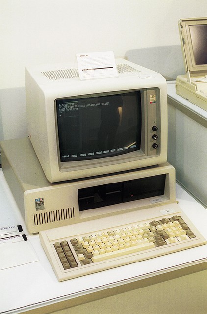 IBM PC XT - Leto izdelave: 1983, IBM-ov prvi osebni računalnik ali IBM PC (Personal Computer), kot so ga poimenovali, je pomenil preobrat v osebnem računalništvu. Osebni računalnik je bil prvič standardno razširljiv, kar je omogočilo razvoj industrije dodatkov zanj, zaradi vendarle premajhne intelektualne zaščitenosti pa se je kmalu razvila industrija združljivih računalnikov, ki jo poznamo še danes. Prvi IBM PC je bil predstavljen leta 1981, imel je 16 KB pomnilnik (največ 64 KB), disketno enoto z zmogljivostjo 160 KB, vgrajen programski jezik basic in črno-bel monitor. IBM PC XT je bil predstavljen dve leti pozneje. Razstavljeni model je opremljen z originalnim DOS-om, barvnim monitorjem cga, kmalu pa še z windows 1.0. Cena okoli 7500 dolarjev.