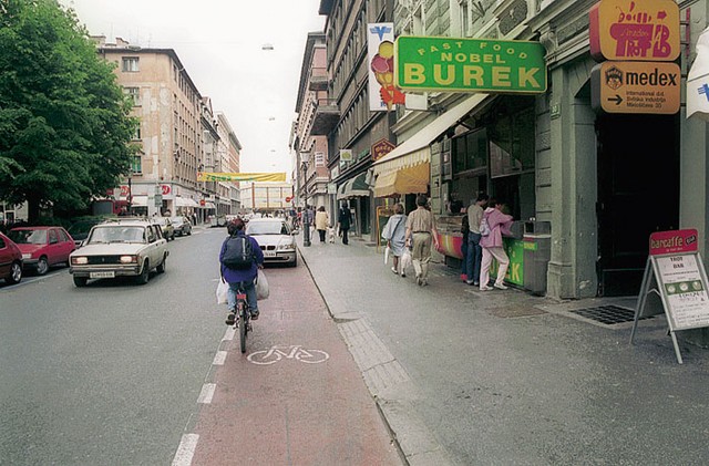 Kolesarski pas na Miklošičevi cesti ima več točk, na katerih avtomobilisti redno ustavljajo avtomobile, da 'skočijo' na burek (na sliki), po zdravila v dežurno lekarno ali še kam. Kolesar, ki mora voziti mimo parkiranega avta, se izpostavlja nevarnosti nasproti vozečega motornega prometa.
