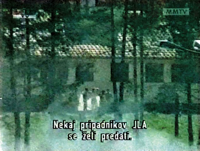 Posnetek dogajanja na Holmcu, kot ga je videla ORF: Vojaki JLA se predajo z belimi zastavami, zasliši se streljanje in vojaki padejo na tla (ali pa poležejo)