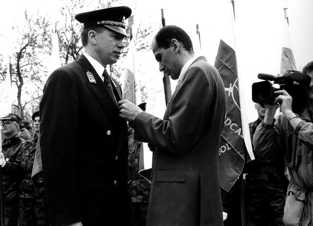 Janez Janša, takratni minister za obrambo, pripenja odlikovanje Albinu Gutmanu, takrat polkovniku. Dan slovenske vojske, 16. maj 1993