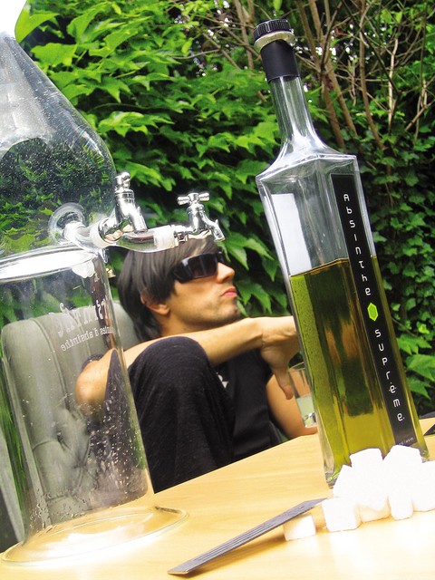 V ospredju posoda za kaplanje absintha, v ozadju najfamoznejši absinter Lado