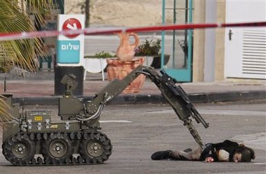 Policijski robot pregleduje truplo Palestinca, ki je nameraval zažgati bencinsko črpalko nedaleč od Jeruzalema. Od začetka izraelske ofenzive je minilo že 14 dni: na palestinski strani je bilo ubitih več kot 700 ljudi, na izraelski – 9 vojakov.