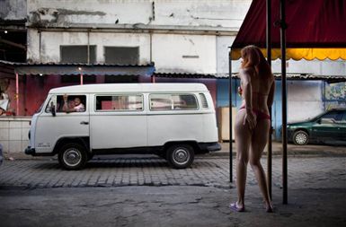23-letna spolna delavka čaka na stranke v Vili Mimosi, ''rdeči četrti'' Ria de Janeira, ki naj bi v kratkem postala del trase za hitro železnico med Riom in Sao Paulom.