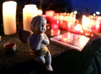 Porcelanasti angel in sveče pred šolo v Albertvillu, v južni Nemčiji, ki je bila v sredo prizorišče grozljivega pokola. Mladoletnik je pobil 15 ljudi in se nato pokončal. Nekateri šolarji so ob smrti v rokah še držali svinčnike...