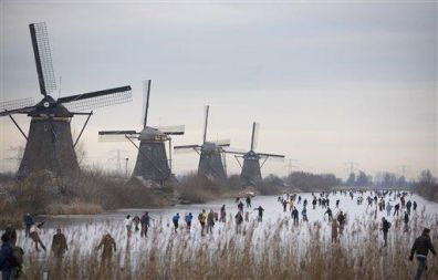 Drsalci na zaledenelem nizozemskem kanalu Kinderdijk blizu Rotterdama, ob mlinih na veter, ki jih je Unesco uvrstil med svetovno kulturno dediščino.