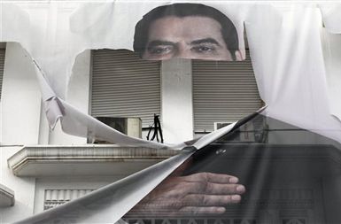 Podoba nič več ljubljenega predsednika Zina El Abidina Ben Alija na veleplakatu v središču Tunisa.