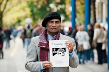 Bashy Quaraishy s plakatom za svoje predavanje v Ljubljani