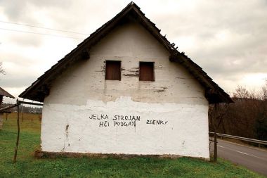 Spomin na pogrom v Ambrusu. Grafit o Jelki Strojan v vasi Fužina na poti proti Ambrusu tri leta po nasilni izselitvi romske družine.