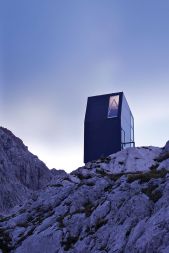 S Plečnikovo medaljo nagrajeni bivak na Velikih podih pod Grintovcem je postavljen kot orientacijska točka v obsežni in nepregledni kraški pokrajini gorske planote.