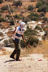 Palestinski fant, ki meče kamen s fračo.  