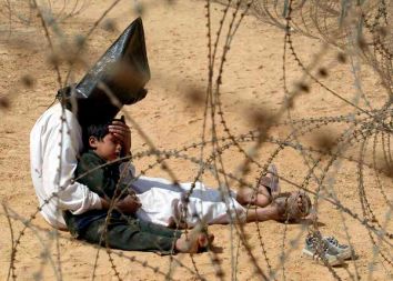 Iraški vojaški ujetnik tolaži svojega sina v ameriškem centru za pridržanje blizu An Najafa, v Iraku, med zavezniško invazijo, marec 2003; fotografija je dobila nagrado World Press Photo leta 2004