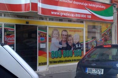Družina v izložbenem oknu praške trgovine