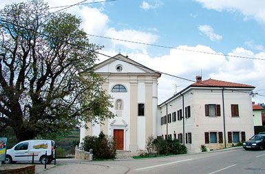 Župnišče, kjer bi morala stati plošča, in cerkev v Kojskem
