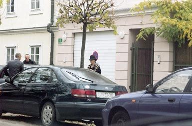 Gospa Rupel med vstopanjem v službeni avto svojega moža pred svojo hišo
