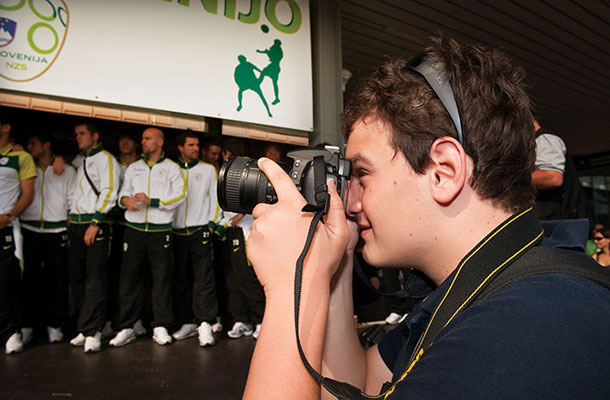 Fant z avtizmom, ki je navdušen nogometni navijač med fotografiranjem prihoda slovenske nogometne reprezentance
