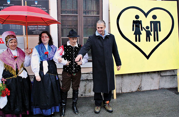 Narodne noše in Aleš Primc pred škofjeloško upravno enoto ob ponovnem zbiranju podpisov za referendum o družinskem zakoniku
