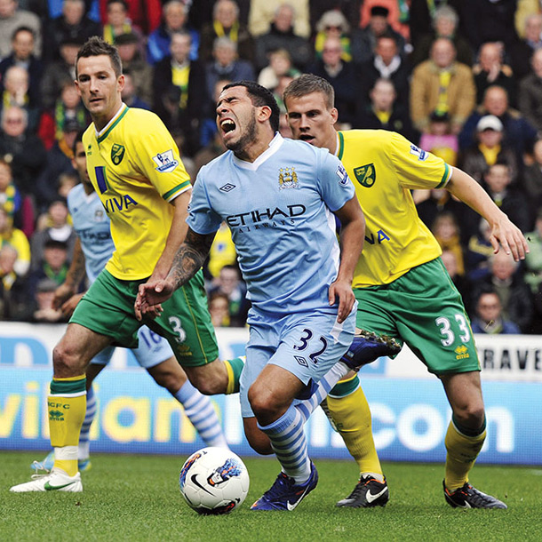 Napadalec angleških prvakov Manchester City Carlos Tevez trpeče pada v kazenskem prostoru. Sodnik mu je dosodil rumeni karton zaradi simuliranja. 