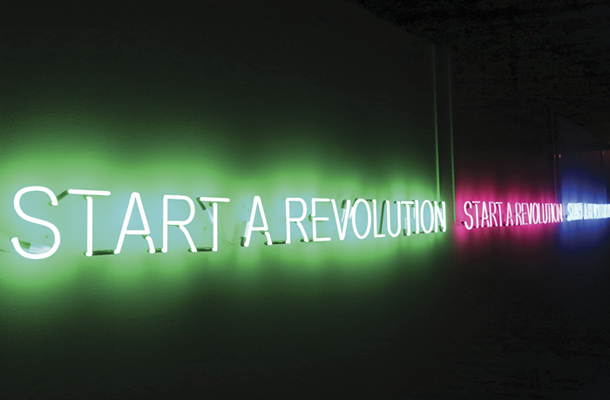 Obarvan neonski napis poziva k revoluciji. 