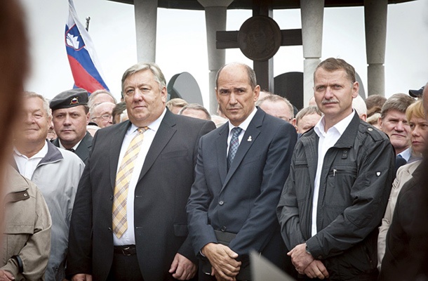 Kaplan vojaškega vikariata Milan Pregelj (z vojaško baretko) je kulturni del slovesnosti v Rovtah spremljal ob logaškem županu Bertu Menartu in predsedniku SDS Janezu Janši