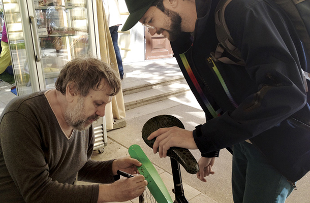 Slavoj Žižek podpisuje zložljivi blatnik za kolo, za katerega je Jurij Lozić na Kickstarterju zbral 44.633 dolarjev  in ki ga je Spiegel razglasil za idealno božično darilo za kolesarje 