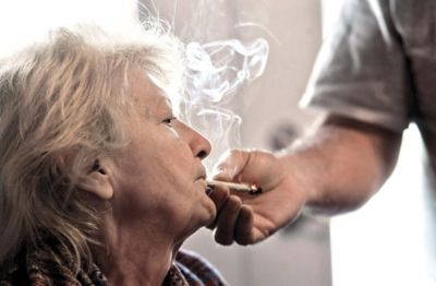 Neželeni učinek je lahko tudi zaželen. Za to 63-letno bolnico z atrofično lateralno sklerozo so suha usta blagodejna, ker ji slina ne teče po bradi. Sama ni več zmožna držati cigarete, zato ji pomaga njen mož.