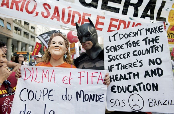 Protesti zoper svetovno prvenstvo v nogometu na ulicah Ria de Janeira. Med množico je bil tudi človek, oblečen v Batmana, in protestnica z masko brazilske predsednice Dilme Rousseff.