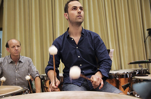 Udeleženec mojstrskega tečaja za timpaniste med skupinsko lekcijo z orkestrom, kjer mladi glasbeniki dobijo informacije o tem, kako dirigent razmišlja in deluje ter zakaj ravno tako.