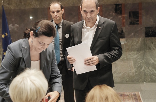 Zapornik Janez Janša nekaj trenutkov pred ustanovno sejo parlamenta. Predstavnikom strokovnih služb državnega zbora je izkazal istovetnost in pridal originalno potrdilo Državne volilne komisije o svoji izvolitvi.