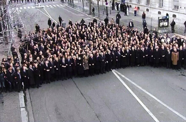 Fotografija prve vrste politikov na pohodu v Parizu od zgoraj, na kateri se lepo vidi varnostni, sanitarni kordon, ki politike ločuje od ljudskih množic
