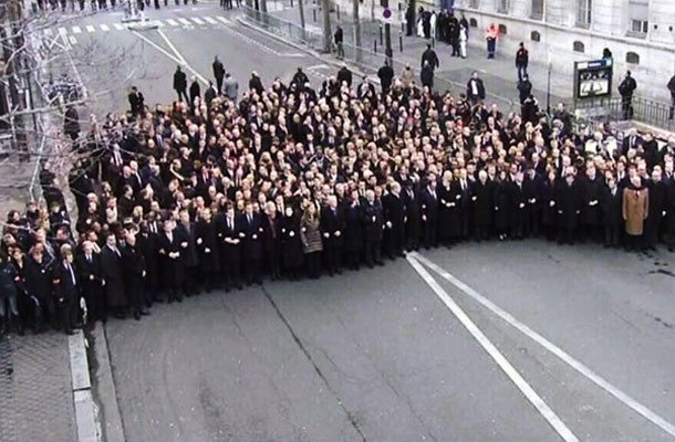 Fotografija prve vrste politikov na pohodu v Parizu od zgoraj, na kateri se lepo vidi varnostni, sanitarni kordon, ki politike ločuje od ljudskih množic