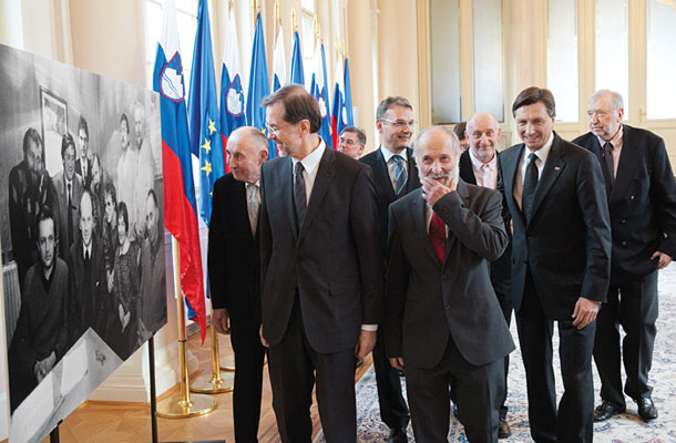 Foto tedna: Sprejem za udeležence ustanovnega sestanka koalicije Demos pri predsedniku republike Borutu Pahorju. Ivan Oman, Lojze Peterle, Rajko Pirnat, Marjan Podobnik, Vitomir Gros, Dušan Plut in Dimitrij Rupel (v ozadju še Andrej Magajna in Leo Šešerko) ob 25 let stari fotografiji ustanovnega sestanka (fotografijo je posnel Tone Stojko, tedaj urednik fotografije na Mladini).