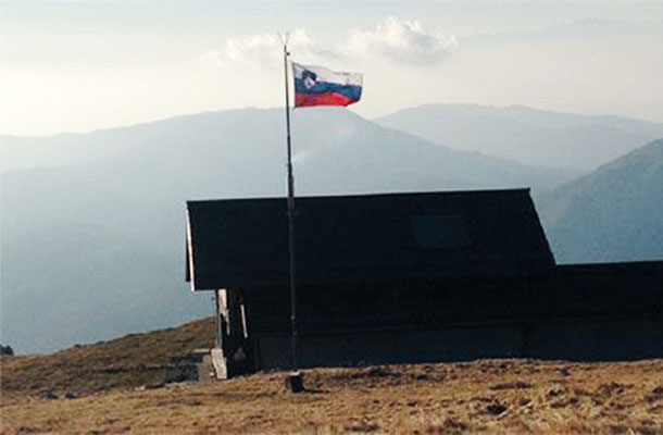 Slovenska zastava, izobešena na planinski koči na italijanski strani Matajurja