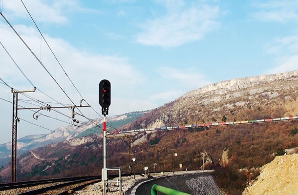 Drugi tir med Divačo in Koprom bi morali zgraditi ob sedanjem tiru v dolžini 31,5 km. Ta proga je sicer za 4,5 km daljša od predlaganega drugega tira. To bi investicijo pocenilo in pospešilo. (na fotografiji pogled s postaje Hrastovlje)
