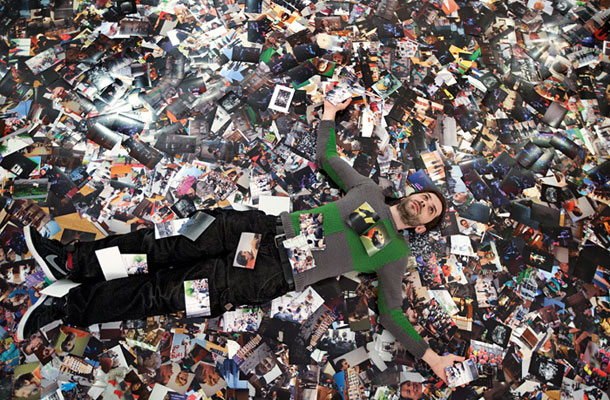 Uroš Abram na tleh galerije, prekritih z njegovo fotografsko »nesnago« 