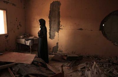 Fatima Asfur se med ruševinami delno poškodovanega doma z materinsko ljubeznijo v agoniji oklepa portretov sinov, ki sta zbežala iz Gaze. V strahu, da sta Ramez (26) in Ahmed (25) potonila z ladjo, ki se je 6. septembra potopila v Sredozemskem morju, čaka na uradne novice o usodi sinov. (Kan Junis, Gaza, 27. 9. 2014)
