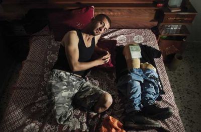 Amar Abu Asi (22) v začasnem domu v mestu Kan Junis. Amar je na invalidskem vozičku skozi podzemni rov iz Gaze zbežal v Egipt v upanju, da se nikoli več ne vrne. S seboj je vzel le nožni protezi, potni list s ponarejenimi vizumi in obleke, ki jih je imel med begom na sebi. (Kan Junis, Gaza, 25. 9. 2014) 