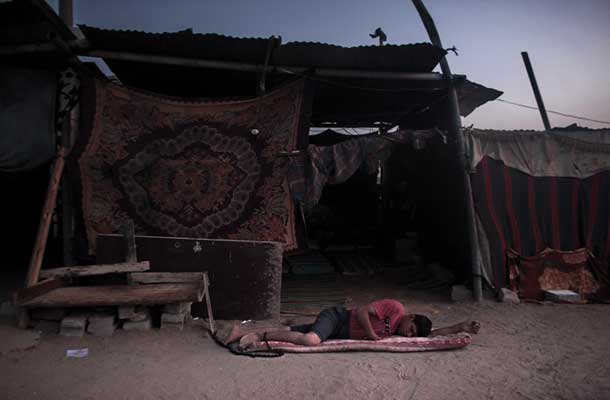 Duševno moteni Sad Za’nen, z verigo priklenjen na klop, leži pred zasilnim bivališčem, ki je novi dom družine Za’nen. Med lansko vojno, trajajočo 51 dni, se je družinska hiša spremenila v ruševine in Sad je tako izgubil edino varno zatočišče – svojo sobo. Z verigo je priklenjen za lastno varnost. (Bejt Hanun, Gaza, 27. 9. 2014)