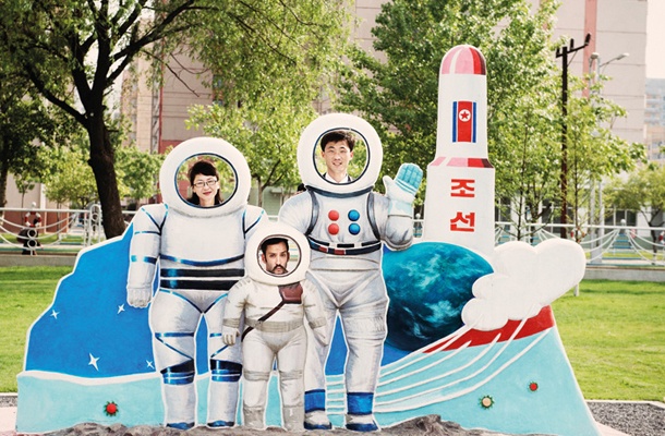 Fotograf Matjaž Tančič (v sredini) pozira s svojima vodičema po Severni Koreji