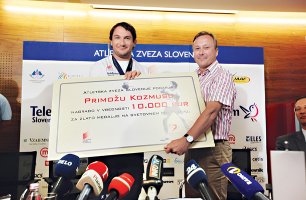 Eden najuspešnejših slovenskih atletov Primož Kozmus s čekom za eno od osvojenih medalj na največjih tekmovanjih. Prihranke je vložil v podrejene obveznice, ki jih je država porezala. 