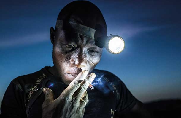 Druga nagrada World Press Photo v kategoriji Ljudje: fotografija, posneta 20. novembra 2015, z naslovom Kopanje prihodnosti. Rudar v Baniju v Burkina Fasu si je pred vstopom v rudnik privoščil cigareto.