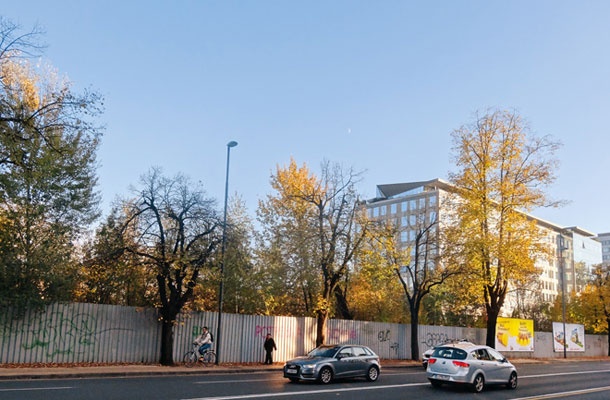 Ograja okoli gradbene jame v lasti države na delu parcele nekdanje topniške vojašnice, kjer naj bi po prvotnih načrtih stala stavba ministrstva za notranje zadeve. V ozadju poslovna Bežigrajski dvor arhitektov M. Kregar, E. Ravnikarja in M. Kerina.