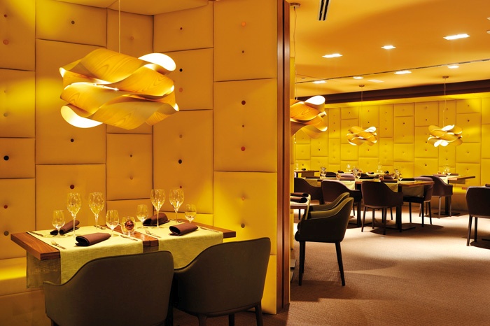 Oblazinjene stene z vidnimi gumbi v ljubljanski restavraciji Element ustvarjajo vtis udobja in po svoje tudi varnosti – kot bi bili zaprti v kokonu. Prostoru dajejo pridih sedemdesetih let prejšnjega stoletja, ki ga dopolnjujejo velike svetilke iz zvitega lesenega furnirja.