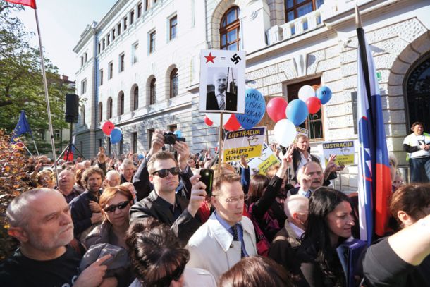 Klemen Jaklič (v belem dežnem plašču) na protestih v podporo Janezu Janši pred vrhovnim sodiščem v Ljubljani.