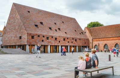 Kannikegården, Ribe, Danska; arhitektura: Lundgaard & Tranberg Architects; finalist. Objekt občinskega župnišča je umeščen na glavni trg srednjeveškega danskega mesta. Projektanti so bili soočeni s težko nalogo, saj so na tej lokaciji ostanki najstarejšega krščanskega pokopališča v regiji. Vitalno vlogo pri arhitekturni zasnovi je zato igral dialog med novim in preteklim. Stavbo tvori enovit, podolgovat volumen z visoko dvokapno streho, ki stoji na kolonadi stebrov. Ti so umeščeni v pritličje z namenom predstavitve arheoloških ostankov. /