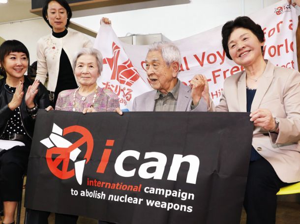 Nobuo Miyake (drugi z desne) je preživel eksplozijo atomske bombe v Hirošimi. V rokah drži transparent mednarodne organizacije, ki je dobila letošnjo Nobelovo nagrado za mir