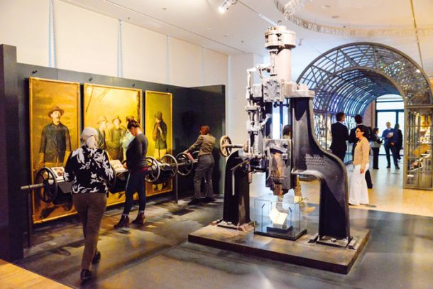 Muzejska predstavitev enega izmed prvih parnih strojev, spodaj pod njim pa Kapital Karla Marxa.